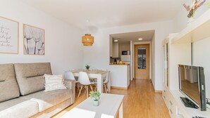 Un salon moderne avec un canapé, une table à manger et un téléviseur.