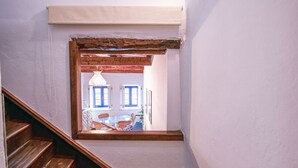 En trappa som leder upp till en balkong med utsikt över en byggnad med blå fönster och en vit lyktstolpe.
