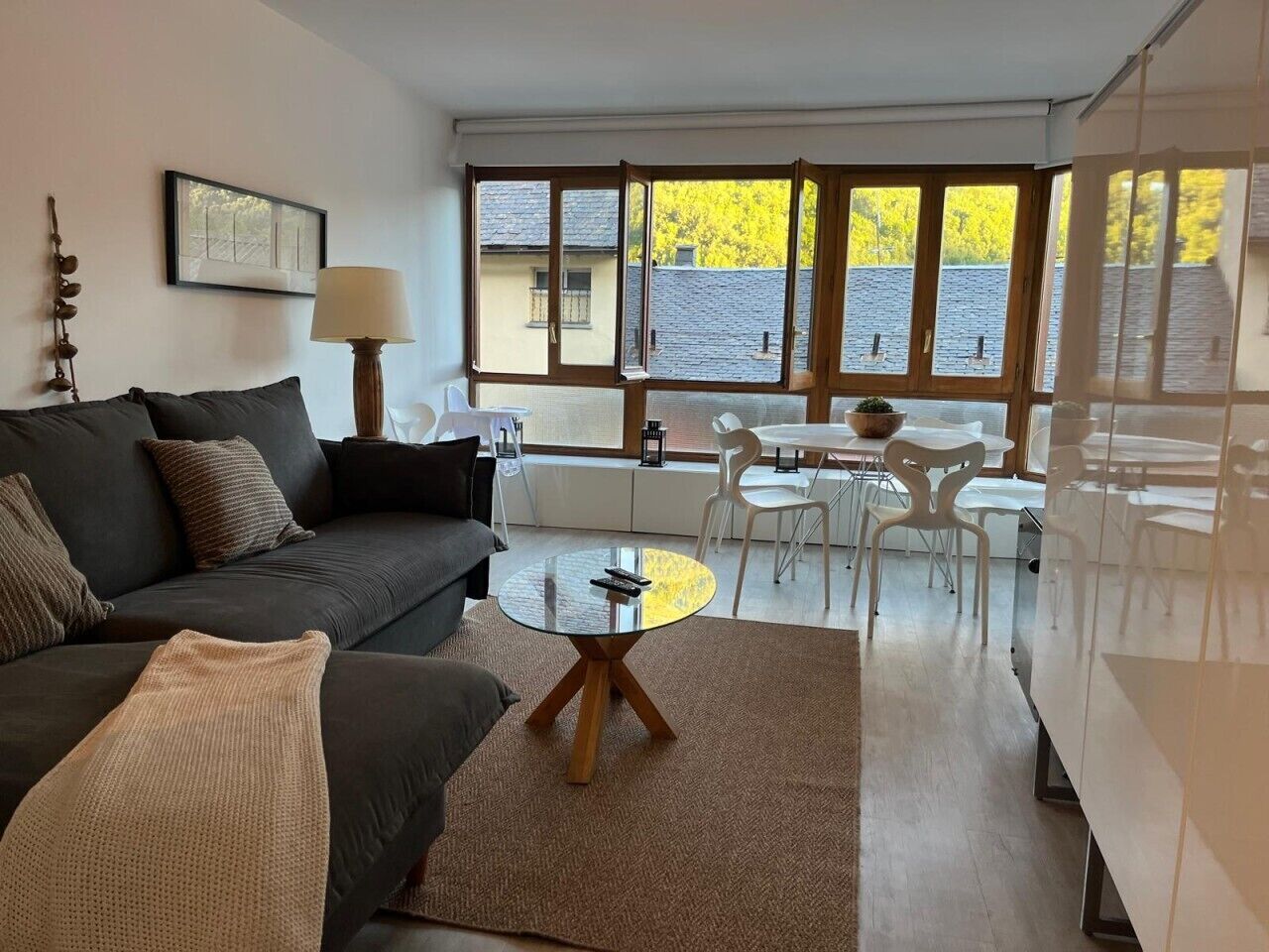 Un salon moderne avec un canapé, une table basse ronde et un coin repas comprenant des chaises et une table.
