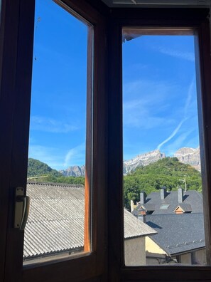 A window with a view of a mountain range and a residential area.