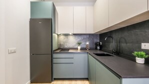 A compact kitchen with a built-in refrigerator, a sink, and a countertop.