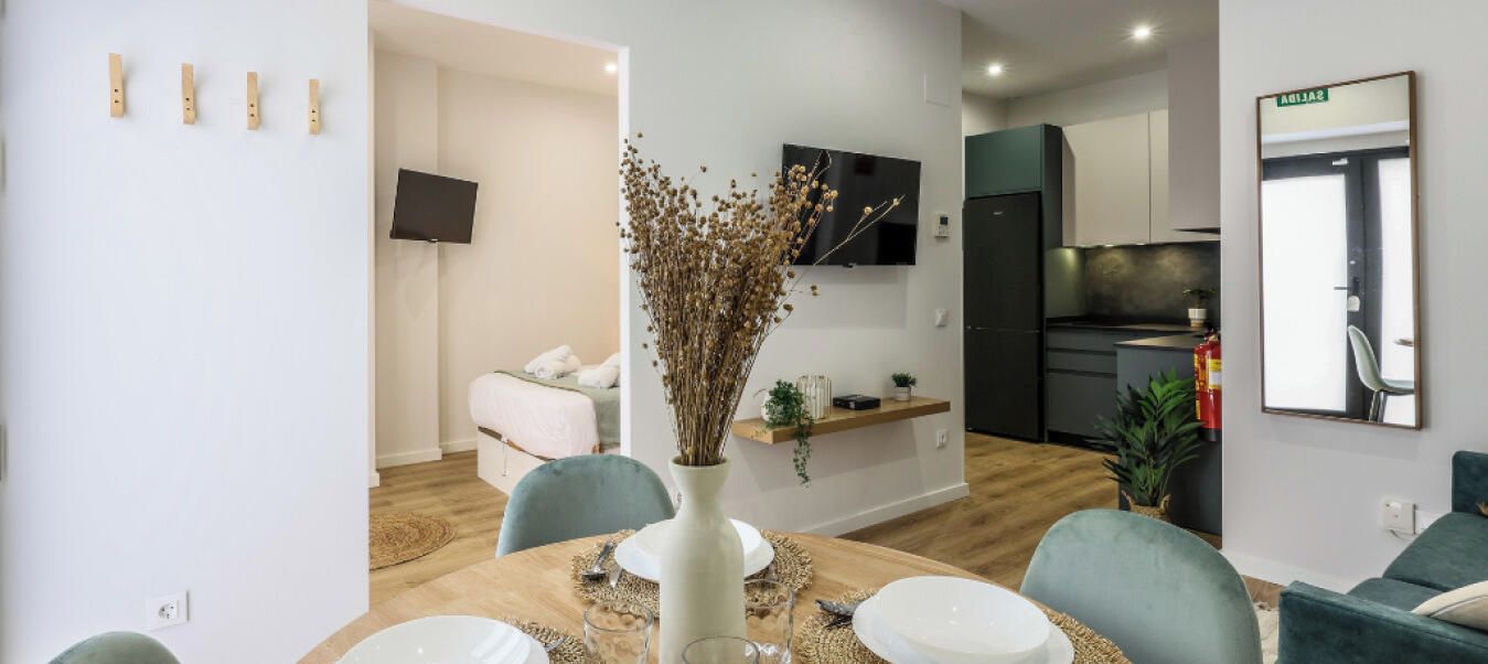 Een moderne woonruimte met een eethoek, kitchenette en een slaapkamer.