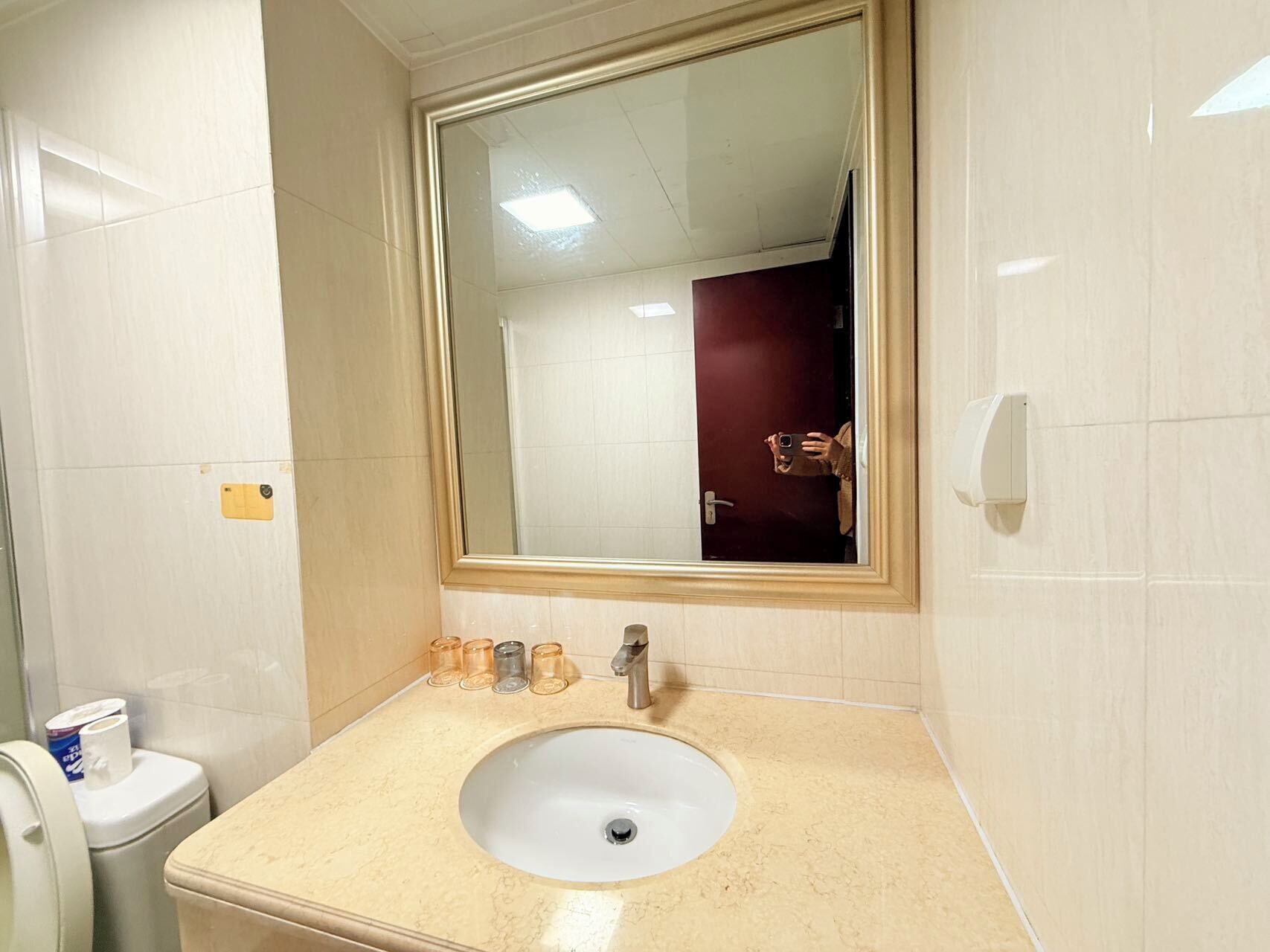 Un baño con lavamanos blanco, espejo y retrete.