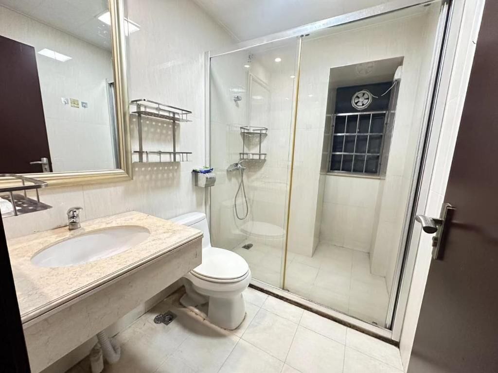 Une salle de bain moderne avec une douche à parois de verre, un lavabo et des toilettes.