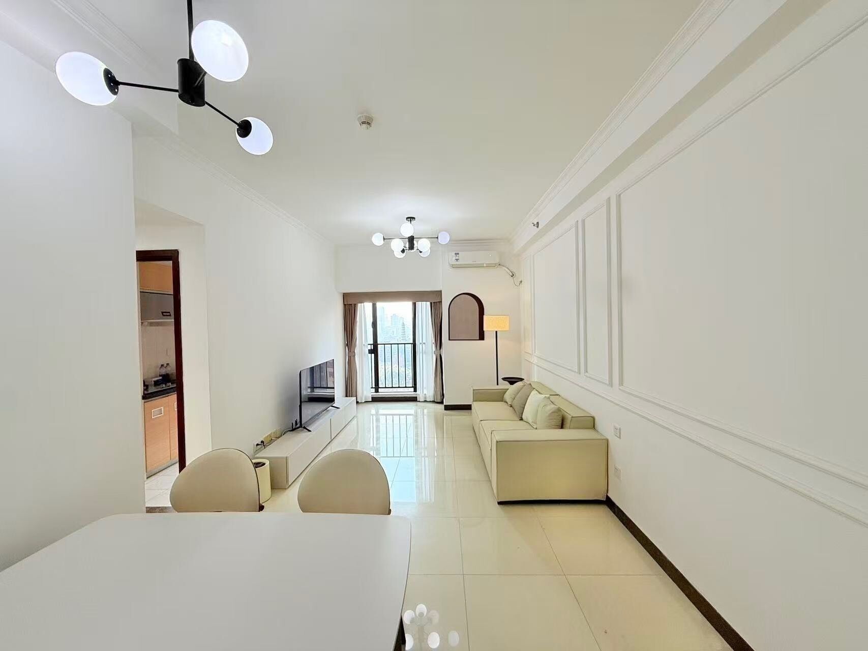 A modern living room with a dining area, a sofa set, and a TV.