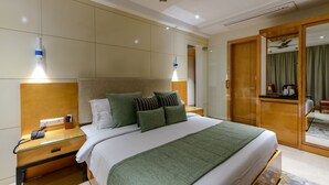 Et hotelværelse med en seng, et natbord og et klædeskab.