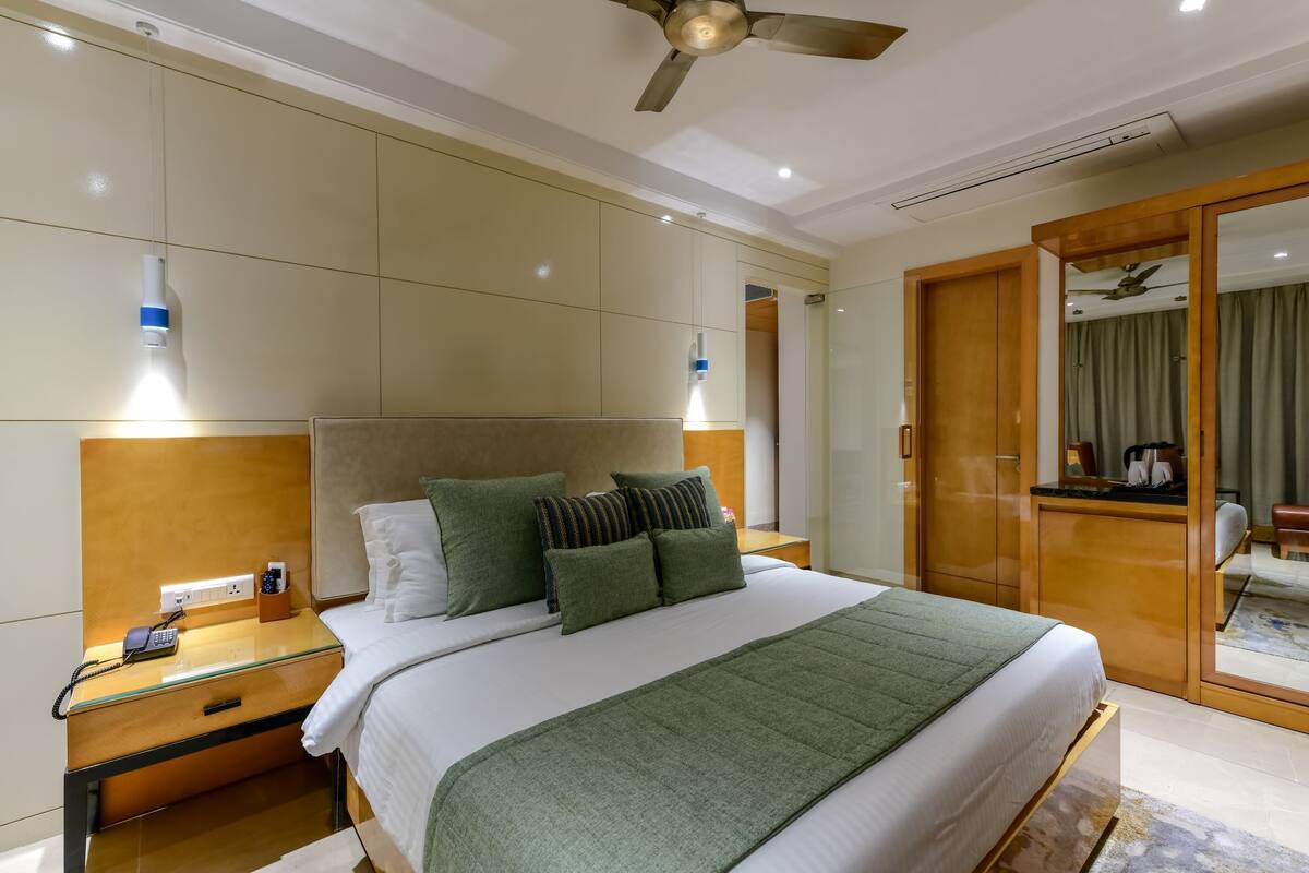 Ein Hotelzimmer mit Bett, Nachttisch, Schrank und Kleiderhaken.