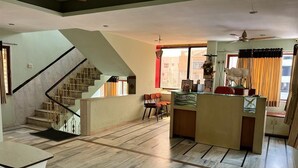 Ein großzügiger Wohnbereich mit Treppe, einer Rezeption und Blick ins Freie.