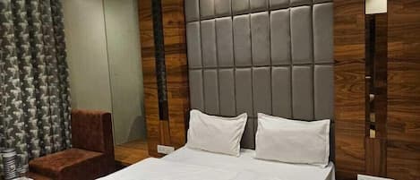Quarto moderno com cama grande, cabeceira de madeira e ventilador de teto.