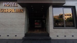 Ein Hotel Eingang mit einem Schild, auf dem 'HOTEL PUSHPAIN' steht.