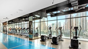A gym with treadmills, elliptical machines, and a blue floor.