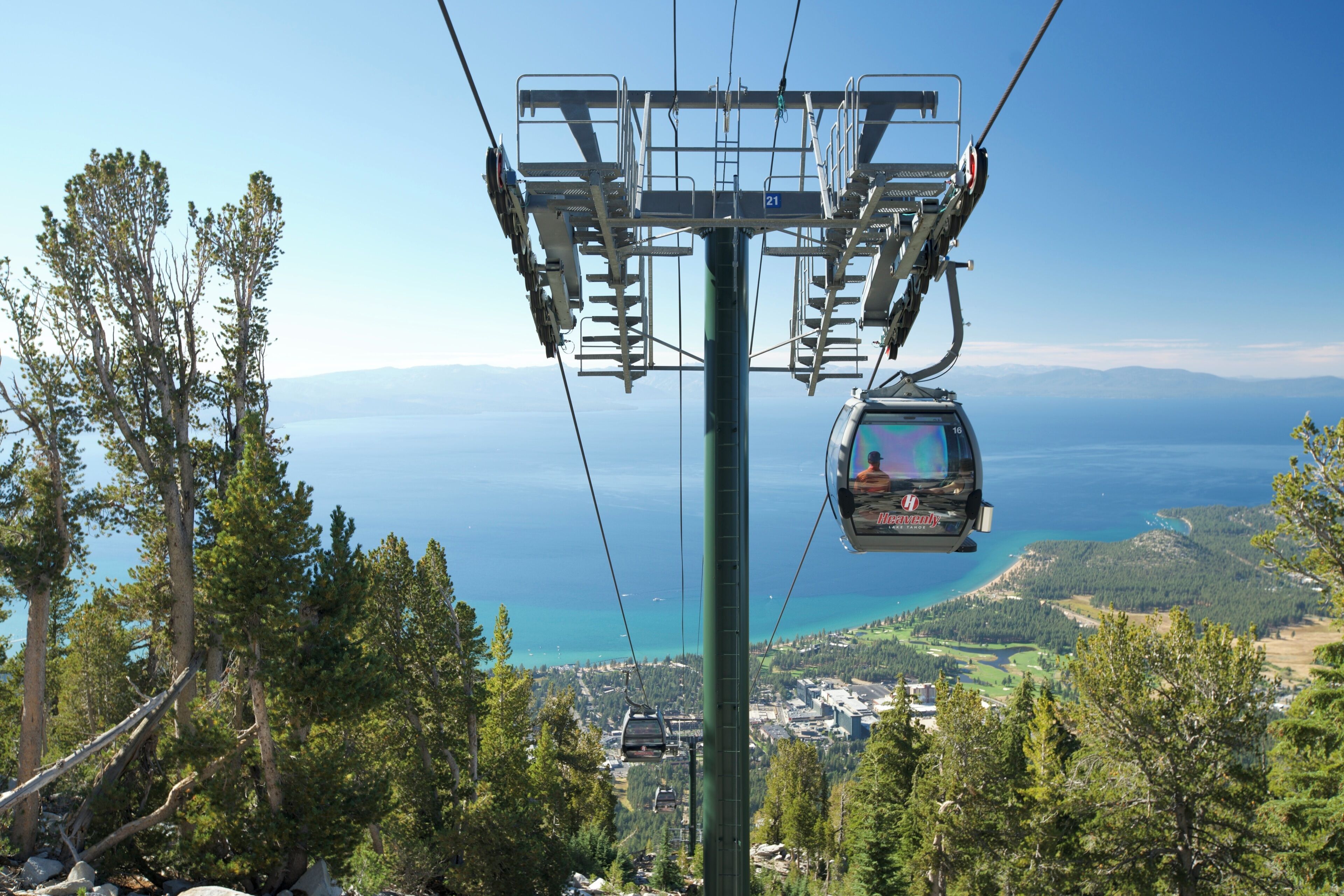 A cable car system with a clear view of a coastal landscape and a distant city.