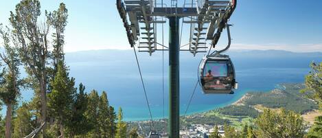 A cable car system with a clear view of a coastal landscape and a distant city.