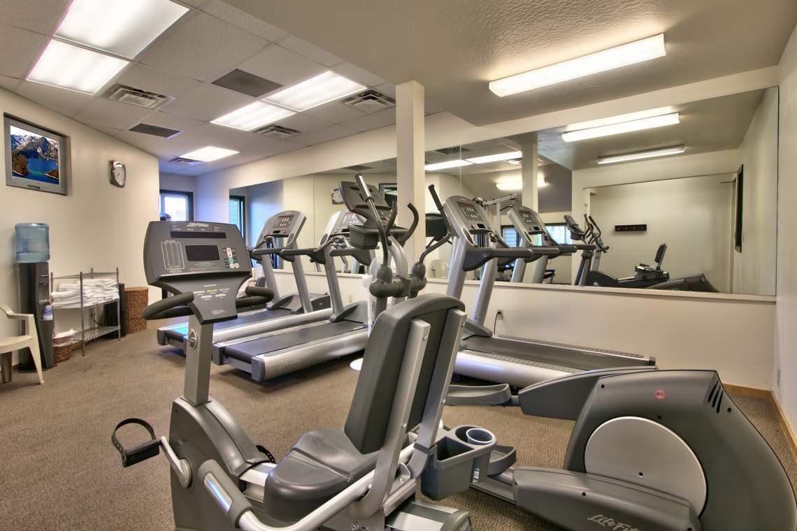 Lakeland Village lodge fitness center featuring cardio machines, treadmills, and free weights to help you maintain your workout routine.