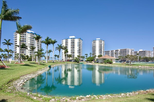 A hotel with multiple high-rise buildings, a central water feature, and palm trees.