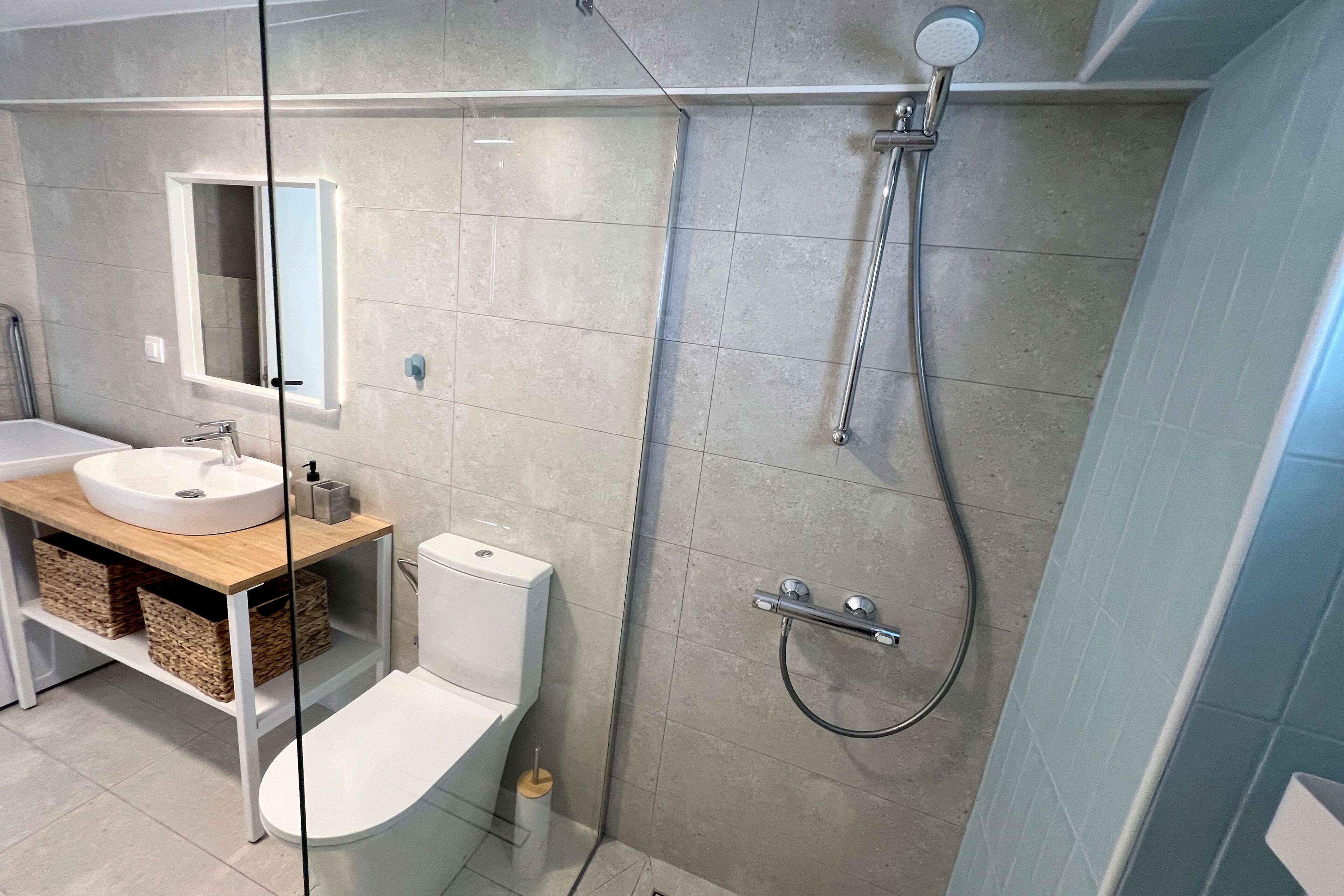 Un baño moderno con inodoro, lavabo y ducha.