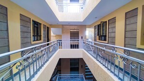 Een meerlaags interieur met een centrale trap, metalen leuningen en uitzicht op de verdieping beneden.