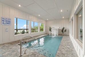 An indoor swimming pool with a sign indicating shallow water and no diving allowed. - Shell Mountain Sunset | Pool, Theater & Epic Views (Sevierville)