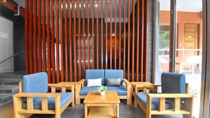 Un área de estar con sofá, dos sillones y una mesa de centro, todo de madera.
