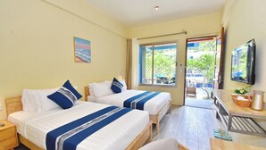Habitación de hotel con dos camas, un escritorio, una silla, un televisor y una ventana con vistas al exterior.
