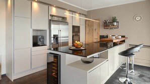 Uma cozinha moderna com ilha central, eletrodomésticos de aço inoxidável e design minimalista.