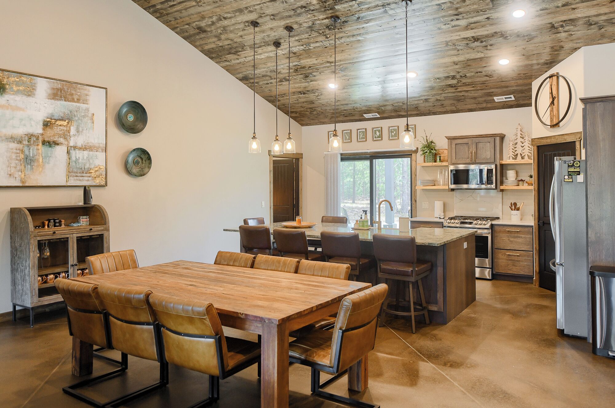 A spacious kitchen with a large island, wooden cabinets, and modern appliances.
