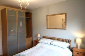 2 habitaciones, escritorio y tabla de planchar con plancha