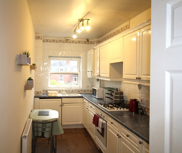 Enjoy cooking in this well-equipped kitchen with a stove, microwave, and kettle.