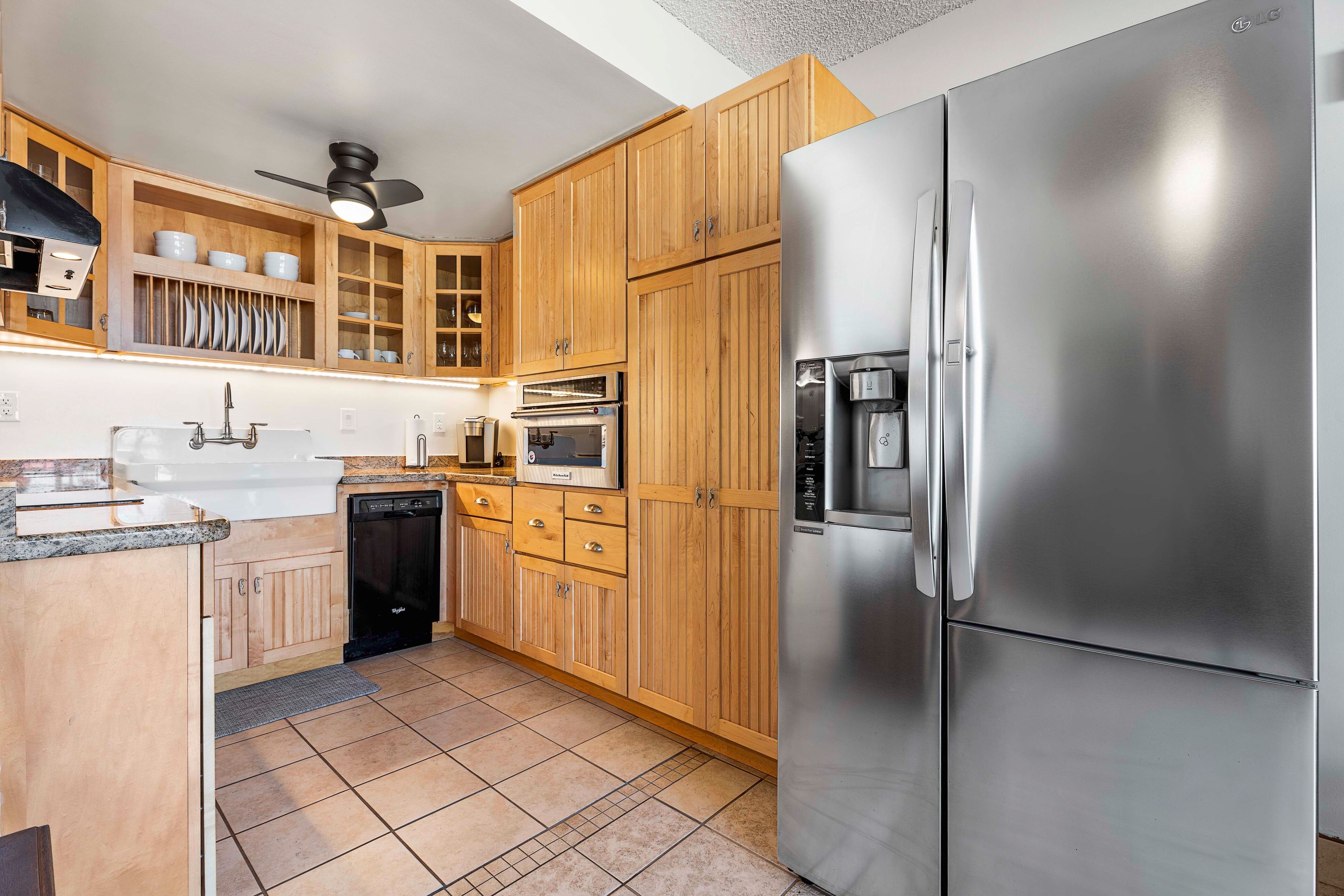 A modern kitchen with wooden cabinets, stainless steel appliances, and a dishwasher.