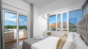Une chambre d’hôtel avec un lit, un bureau et une vue sur l’extérieur.