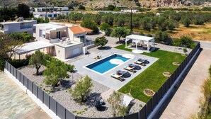 Une villa moderne dotée d’une piscine, d’un espace extérieur aménagé et offrant une vue sur le paysage environnant.