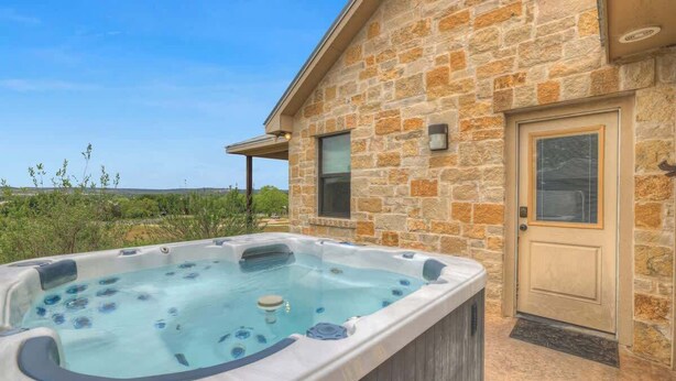Un bâtiment en pierre avec un jacuzzi à l’avant.