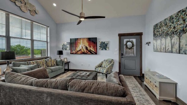 A modern living room with a sectional sofa, a fireplace, and artwork on the walls.
