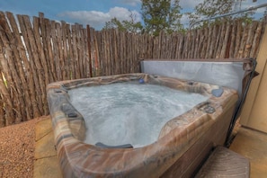 Ein Whirlpool mit Holzzaun im Hintergrund.