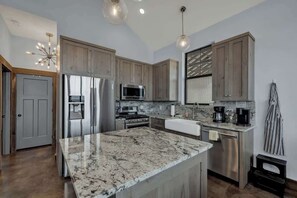 A modern kitchen with granite countertops, stainless steel appliances, and wooden cabinets. - West End Luxury Retreat-Pool/Hot-Tub & Sauna (Fredericksburg)