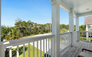 A covered porch with a view of a well-maintained lawn and trees. - Inlet Beach - Private Pool + Fenced Yard & Bikes (Inlet Beach)