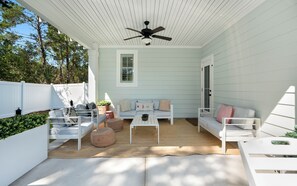 A covered outdoor patio with a ceiling fan, white furniture, and a white fence. - Inlet Beach - Private Pool + Fenced Yard & Bikes (Inlet Beach)