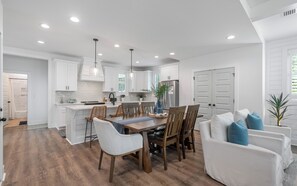 A modern kitchen with white cabinetry, a central island, and pendant lighting. - Inlet Beach - Private Pool + Fenced Yard & Bikes (Inlet Beach)