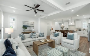 A modern living room with a sofa, coffee table, and a ceiling fan.