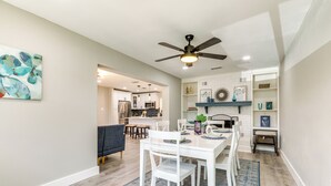 A modern kitchen with white cabinets, a dining area with a white table and chairs, and a ceiling fan. - Tampa Home w/ Covered Patio: 8 Mi to Downtown! (Tampa)