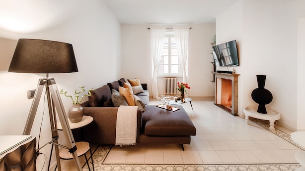 Una sala moderna con sofá, mesa de centro, lámpara de pie y chimenea.