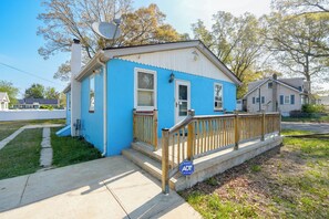 A single-story house with a blue exterior, a wooden front porch, and a satellite dish. - Ideally Located Villas Home: 2 Mi to Beaches! (Villas)