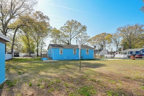 A residential area with a blue house, a grassy yard, and trees with autumn leaves. - Ideally Located Villas Home: 2 Mi to Beaches! (Villas)