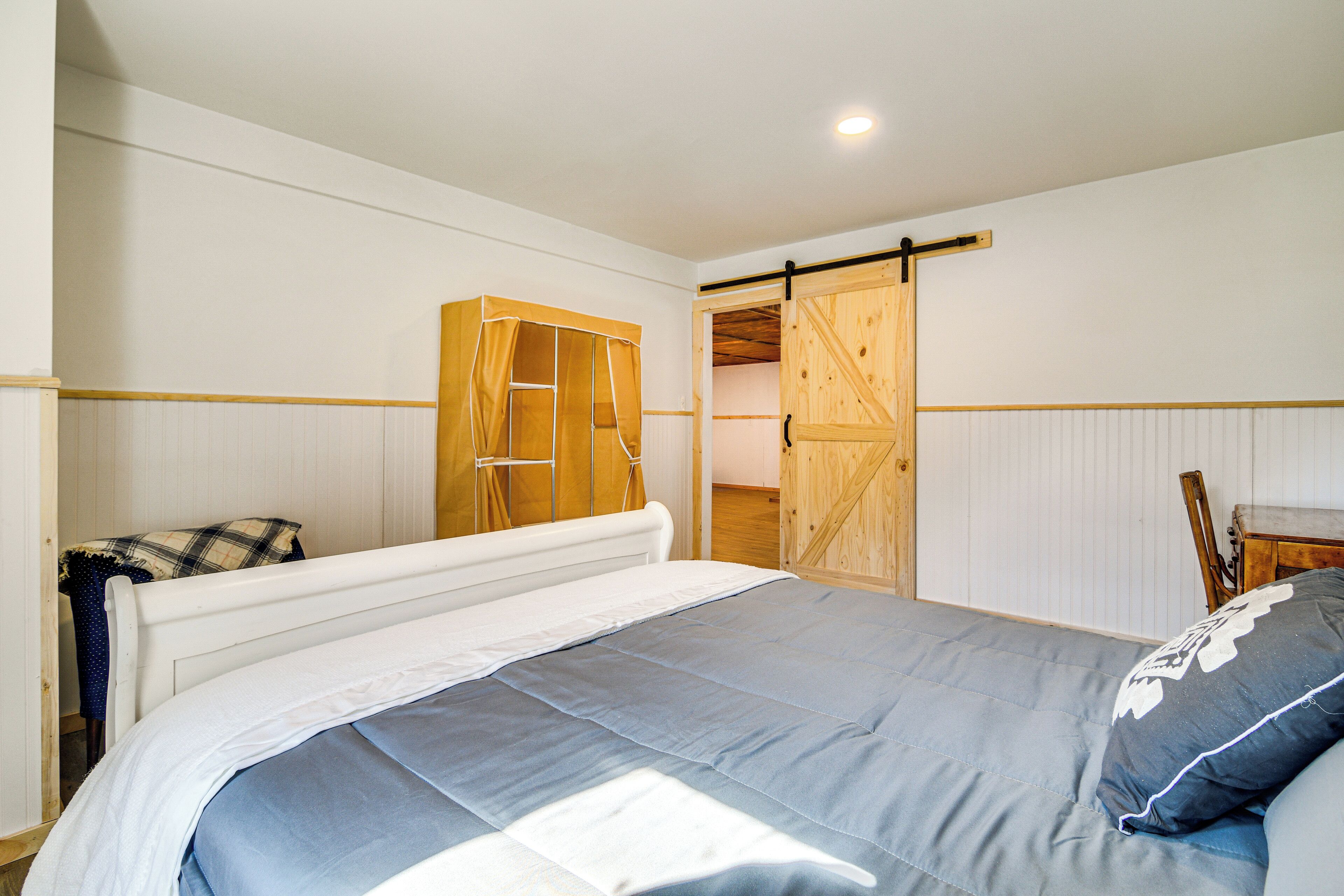 Un dormitorio con cama, un armario de madera y una puerta corredera estilo granero.