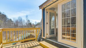 A wooden deck with a glass door leading to a covered outdoor area. - Charming Maine Retreat Near Skiing & ATV Park! (Dixfield)