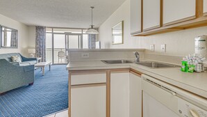 A compact kitchen with a dishwasher, a sink, and a window overlooking a balcony. - Walk to Beach: North Myrtle Beach Resort Apt! (North Myrtle Beach)