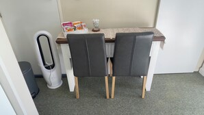 A small dining area with two chairs, a table, and a trash can. - Mel’s Retreat - Private Room & Ensuite (Te Kuiti)