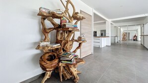 A modern interior with a unique wooden art installation featuring books and a small table. - Nakolodge 4 chambres - piscine / balneo / jardin privatifs  (Sainte-Anne)