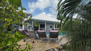 A house with a covered patio, outdoor seating, and a pool. - Nakolodge 4 chambres - piscine / balneo / jardin privatifs  (Sainte-Anne)