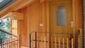 Une cabane en bois avec une porte en bois et une petite fenêtre.